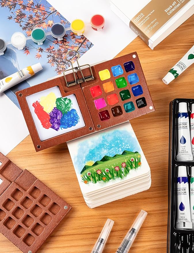 Mini Watercolor Travel Set, Mini Watercolor Paint Set with 2 Wooden 15-Grid Palette, 24 Colors Paint, 2 Sketch Books and 4 Brushes, Copper Clip and Sketchbook for Travel Painting
